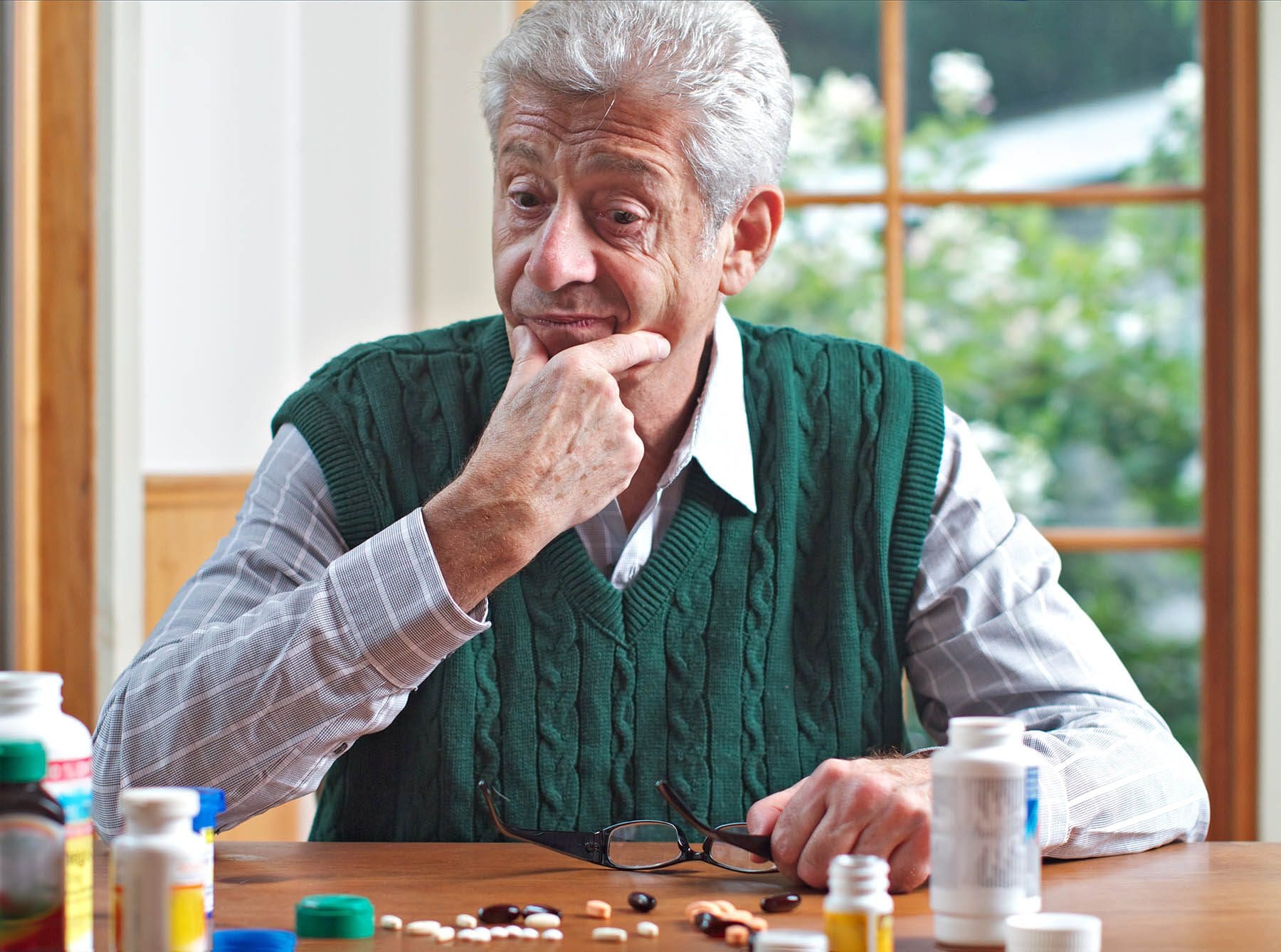 An older man considers the many different treatment options, including TRT and HRT pills.